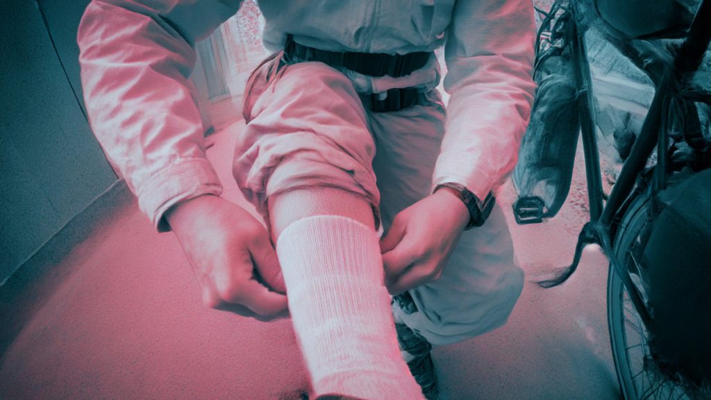 雨や夜道の緊急時に靴下の中に裾を入れて自転車に乗る応急対策シーンのイメージ