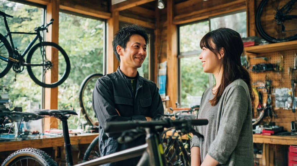 日本人整備士がクロスバイクを点検・調整し、購入後の安心感を示す画像