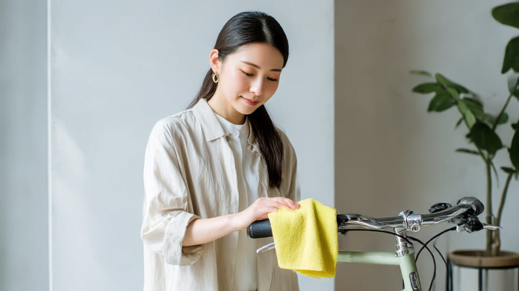 　無水エタノールを使って自転車ハンドルを丁寧に拭き取る日本人女性