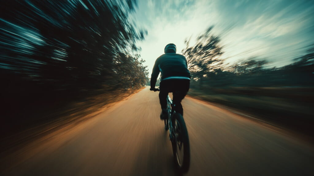 走行中の風を受けながら自転車に乗るサイクリストの様子