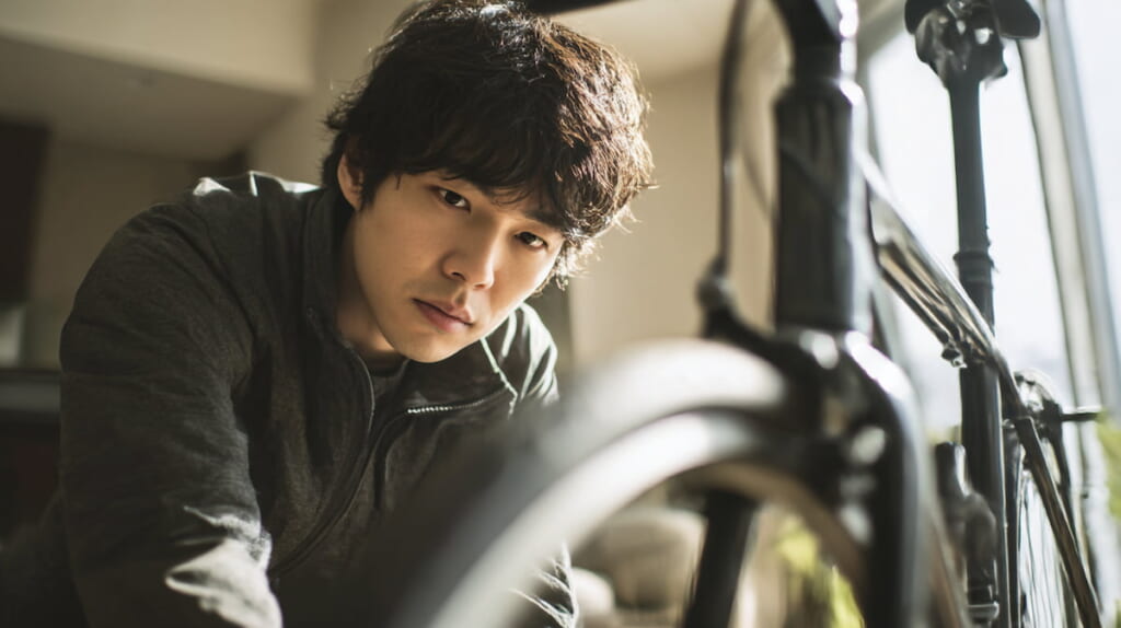 アマゾンで購入した安価なクロスバイクを前に、慎重に確認する日本人男性の様子