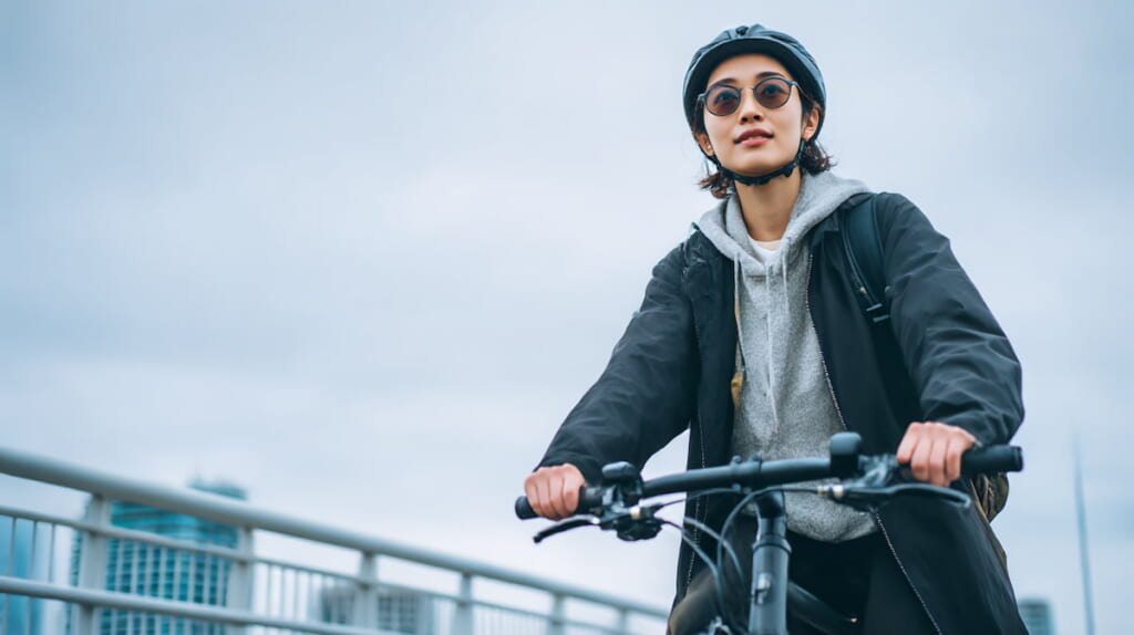 都会でクロスバイクに乗る日本人女性のライフスタイルイメージ