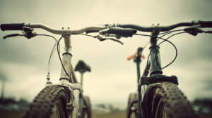 　- クロスバイクとマウンテンバイクを前に通勤用の自転車を選ぶ日本人の通勤者のイメージ