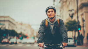 日本の街中をクロスバイクで気持ちよく走る初心者男性サイクリストの様子