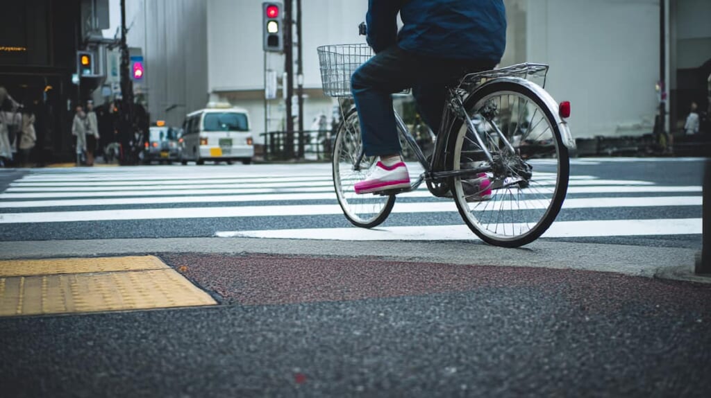 サドルが低すぎる状態で膝を深く曲げて自転車を漕ぐ日本人男性