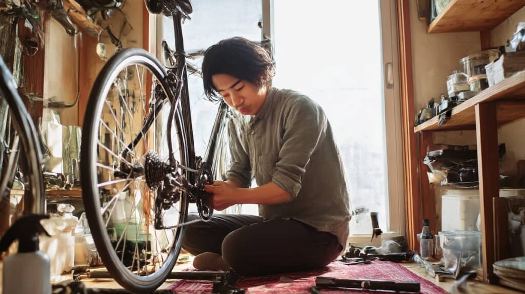 クロスバイクを長く使うために自宅でメンテナンスを行う日本人男性の様子